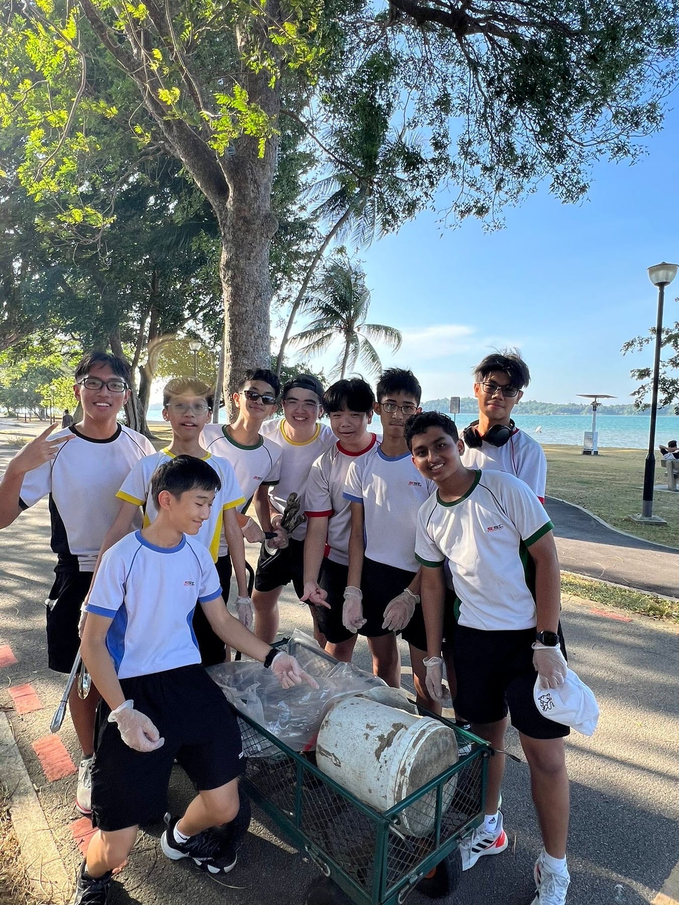 Students gathered around a cart of litter collected at Changi Beach