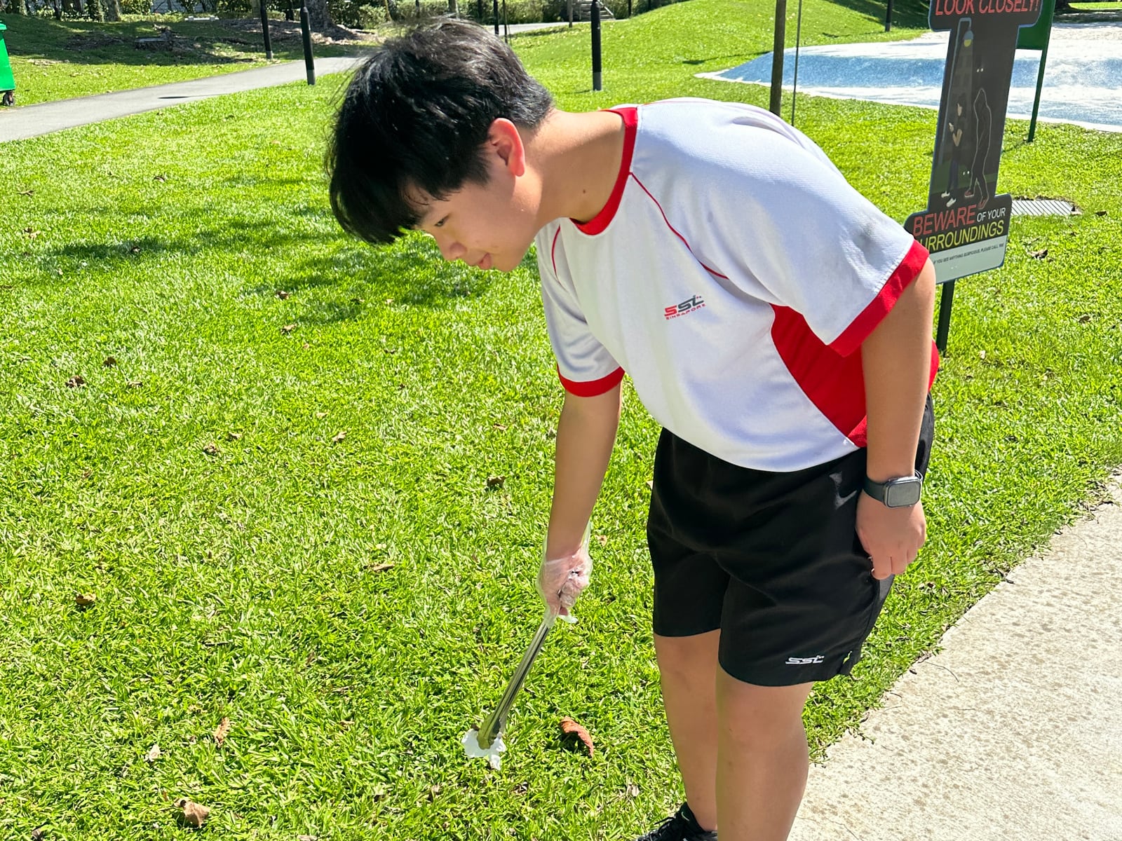 Yi Kai Tan picking up litter at Tiong Bahru Park